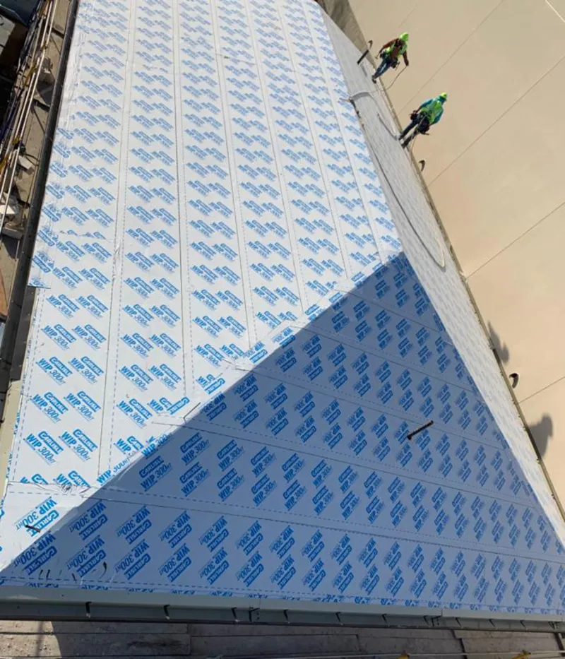 Professional roofers installing underlayment on a metal roof in Wildomar